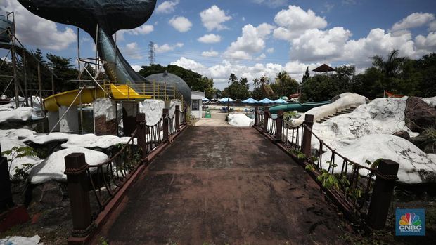 Pekerja melakukan perancangan proyek revitalisasi Taman Mini Indonesia Indah (TMII), Senin (24/1/2022). Snowbay Waterpark dulunya dikenal sebagai wahana favorit anak-anak, sayangnya karena COVID-19, kolam renang dengan berbagai wahana itu harus ditutup selama nyaris 2 tahun. Beberapa kondisi fisik yang terbengkalai terlihat dilokasi ini mulai pintu masuk tiket dan rak tempat penitipan barang. Kondisi Snowbay Waterpark saat ini memang tak terurus karena sudah lama tutup. Sejumlah kolam renang dibiarkan begitu saja hingga airnya keruh. Terlihat juga toko-toko yang dulu menjual perlengkapan renang dan kuliner juga tutup.  
Dikutip dari situs tamanmini.com, Snowbay Waterpark mulanya dirancang secara khusus sebagai taman rekreasi petualangan berkelas dunia berkonsep pegunungan salju
Taman seluas 3 hektar ini dibangun tahun 2008 dan diresmikan pembukaannya oleh ketua Yayasan harapan Kita, Hj. Siti Hardiyanti Rukmana pada tanggal 19 April 2009. Sebelumnya, taman ini adalah Taman Rekreasi Ambar Tirta. (CNBC Indonesia/ Tri Susilo)